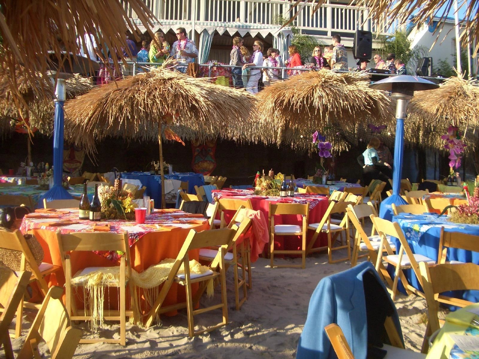 Luau props and decorations — tiki bar, bamboo fencing, and tropical setup